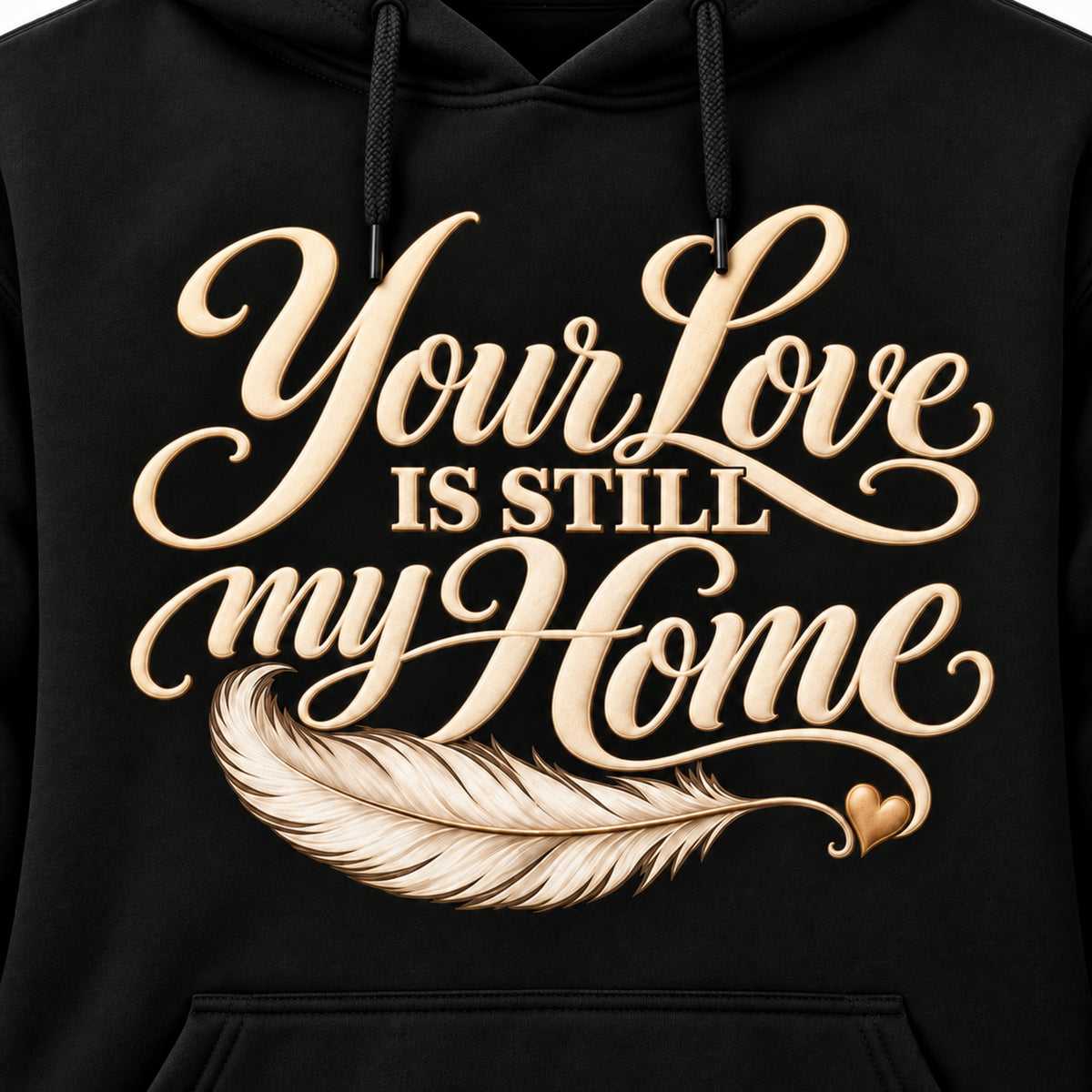 Closeup of cream Your Love Is Still My Home lettering and feather on a black hoodie